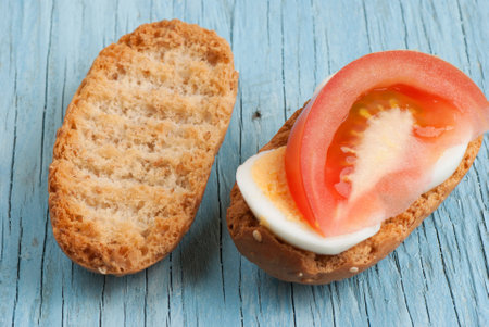 Rusk sandwich with egg and tomato on old wooden tableの写真素材