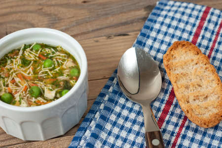 Soup with pasta and vegetables on old wooden tableの写真素材