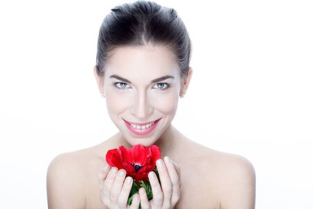 Attractive woman with teeth smile holding red flower, isolated on whiteの写真素材