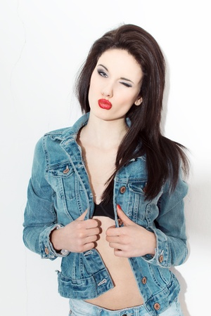 Sexy woman winking in jeans jacketの写真素材