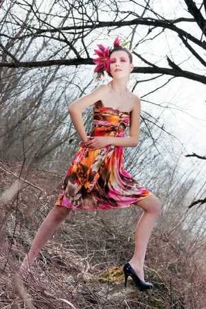 Beautiful woman posing at outdoor in colorful dress and black high heelsの写真素材