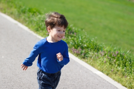 Happy active child running on the roadの写真素材