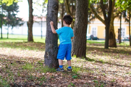 Little kid at tree with stickの写真素材