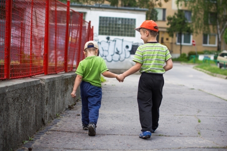 Little caucasian boys walking on sidewalkの写真素材