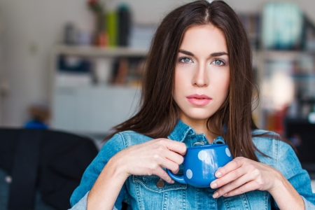 Young wooman with blue mug, white dotsの写真素材