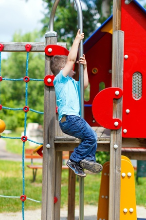Young active boy slip down on the pole at playgroundの写真素材
