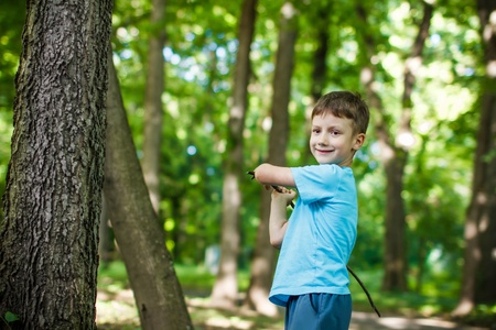 Cute 5 years old boy with branch in the forest, childhoodの写真素材