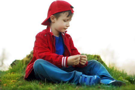 Little innocent child sitting at riverside, natureの写真素材