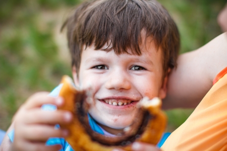 Cute boy eat and show cocoa snailの写真素材