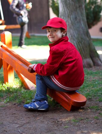 Little boy sitting on seesaw in kindergarten, outdoorsの写真素材