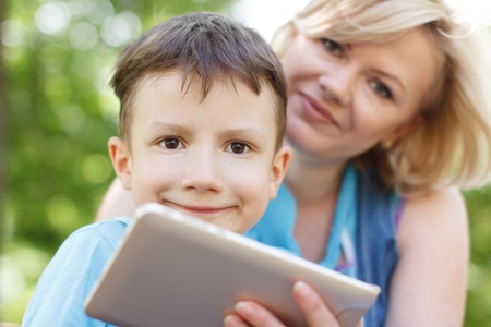 Cute child and mother with tabletの写真素材