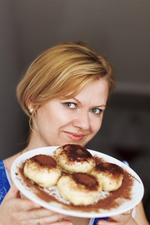 Blonde woman offering tart with cocoa on topの写真素材