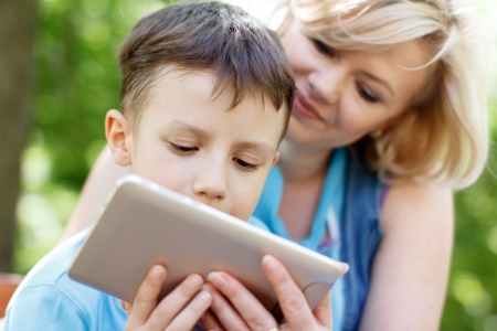 Happy boy and mother with tabletの写真素材