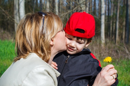 Happy mother hug son with dandelion, outdoorの写真素材