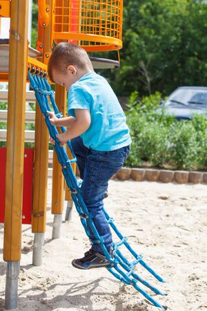 Cute boy climbing at playgroundの写真素材