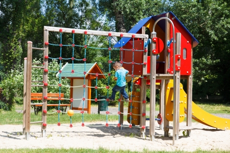 Little boy climbing on rope at playground, outdoorsの写真素材