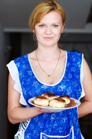 Blonde woman holding tarts with jam and cocoa on plateの写真素材