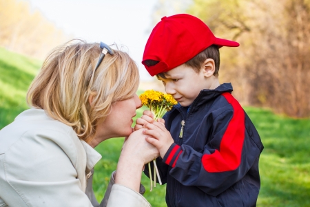 Mother and little boy smelling dandelionの写真素材