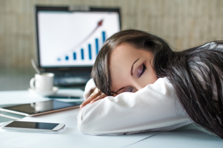 Tired businesswoman at overtime at officeの写真素材