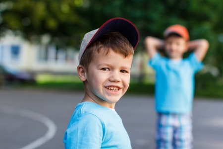 Happy little boy with brother on playgroundの写真素材