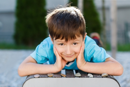 Little boy laying on bench with gravels, childhoodの写真素材