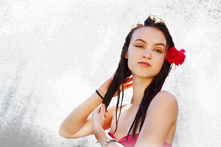 Beautiful woman with red flower in shower, summerの写真素材