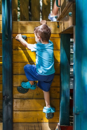 Little boy climbing on jungle gym without rope and helmetの写真素材