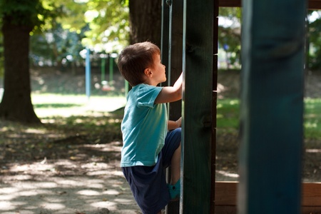 Little boy climbing on jungle gym at parkの写真素材