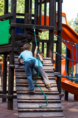 Little brothers playing on jungle gym, outdoorの写真素材