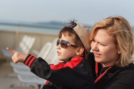 Little boy pointing in glasses with mother, travelの写真素材