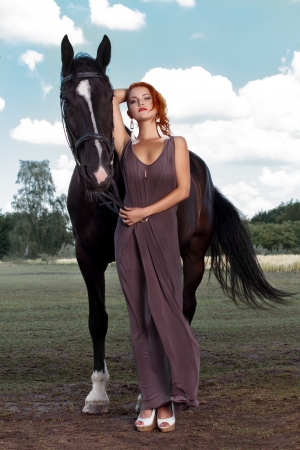 Beautiful young woman with a horse, outdoorの写真素材