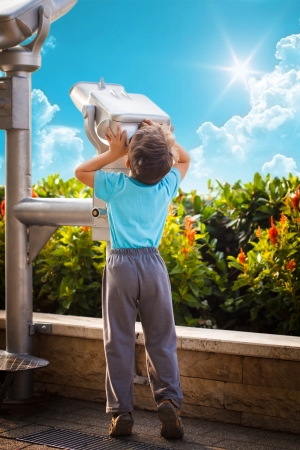 Little boy with telescope gazing the sky, outdoorの写真素材