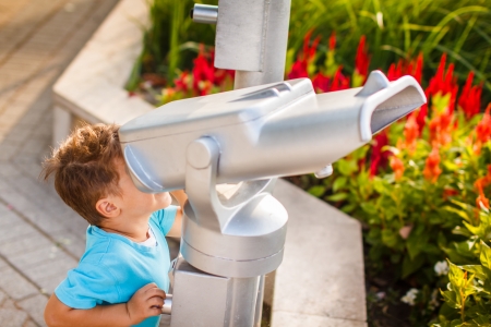 Little boy with telescope gazing, outdoorの写真素材