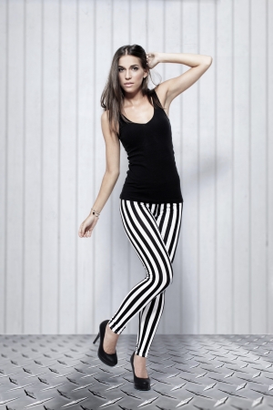 Sexy woman posing in striped leggings and high heelsの写真素材