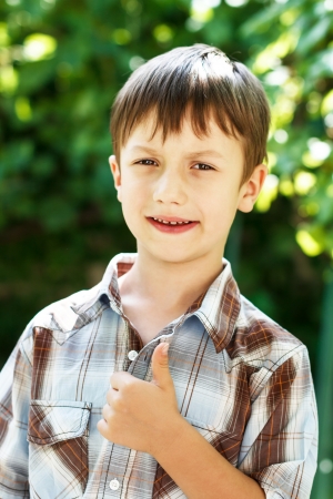 Little preschooler boy thumb up, outdoorの写真素材