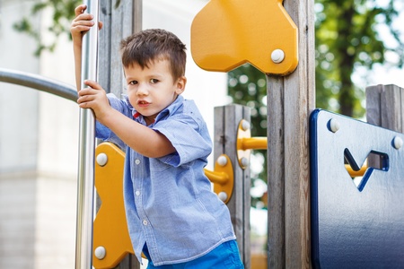 Little caucasian boy slip on pole at jungle gym, dangerousの写真素材