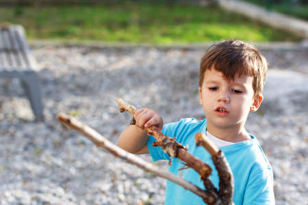 Little boy playing with branch, outdoorの写真素材