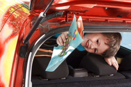 Little boy holding coloring book in car, travelの写真素材