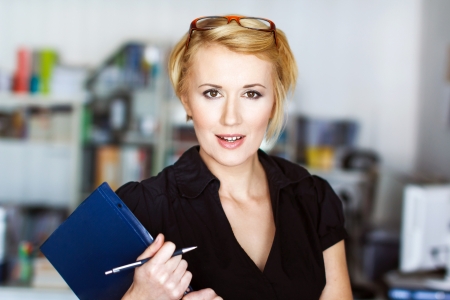 Blonde confident businesswoman holding notepadの写真素材