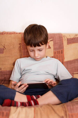 Little boy with tablet at homeの写真素材