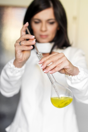 Medical technician with pipette and flask in labの写真素材