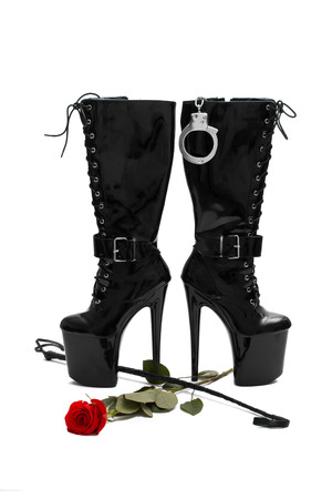 Black platform boots with whip and rose, isolated on whiteの写真素材
