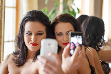 Sexy women selfie together indoorの写真素材