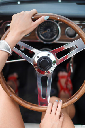 Woman driving car closeup, holding steering wheelの写真素材