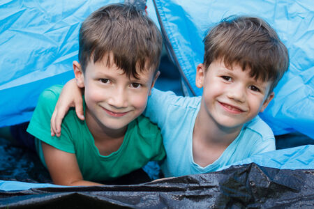 Happy little brothers in tent, outdoor portraitの写真素材