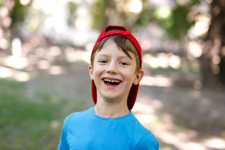Little boy in cap laughing outdoor portraitの写真素材