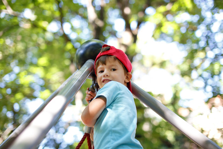 Little boy at top of jungle gym, outdoor portraitの写真素材