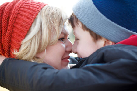 Mother and son huddle together winter portrait, closeupの写真素材