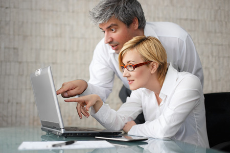 Successful young businesspeople with laptop in officeの写真素材