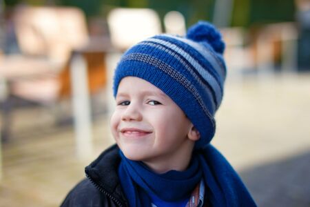 Happy little boy in winter cap and scarf, outdoor portraitの写真素材